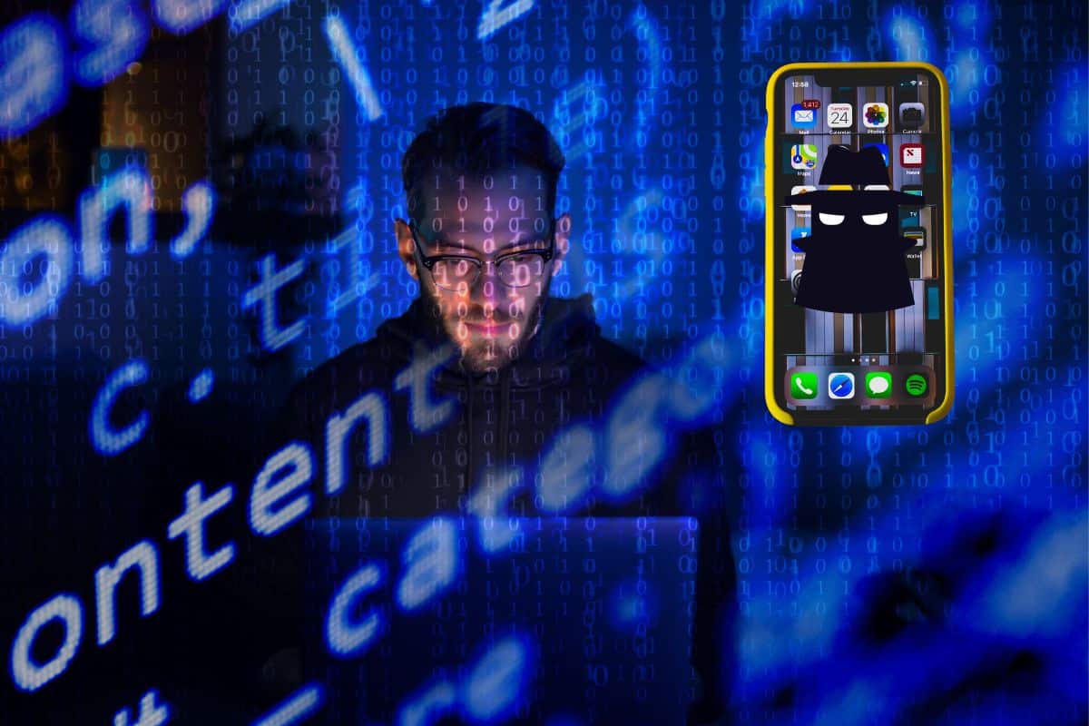 hacker frente a ordenador con un movil junto a el muestra cómo espiar un celular