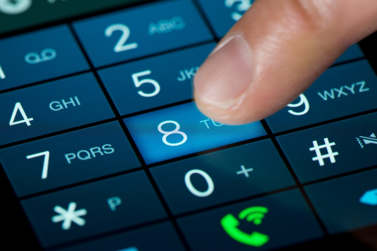Persona marcando un número en un celular y usando el registro de llamadas