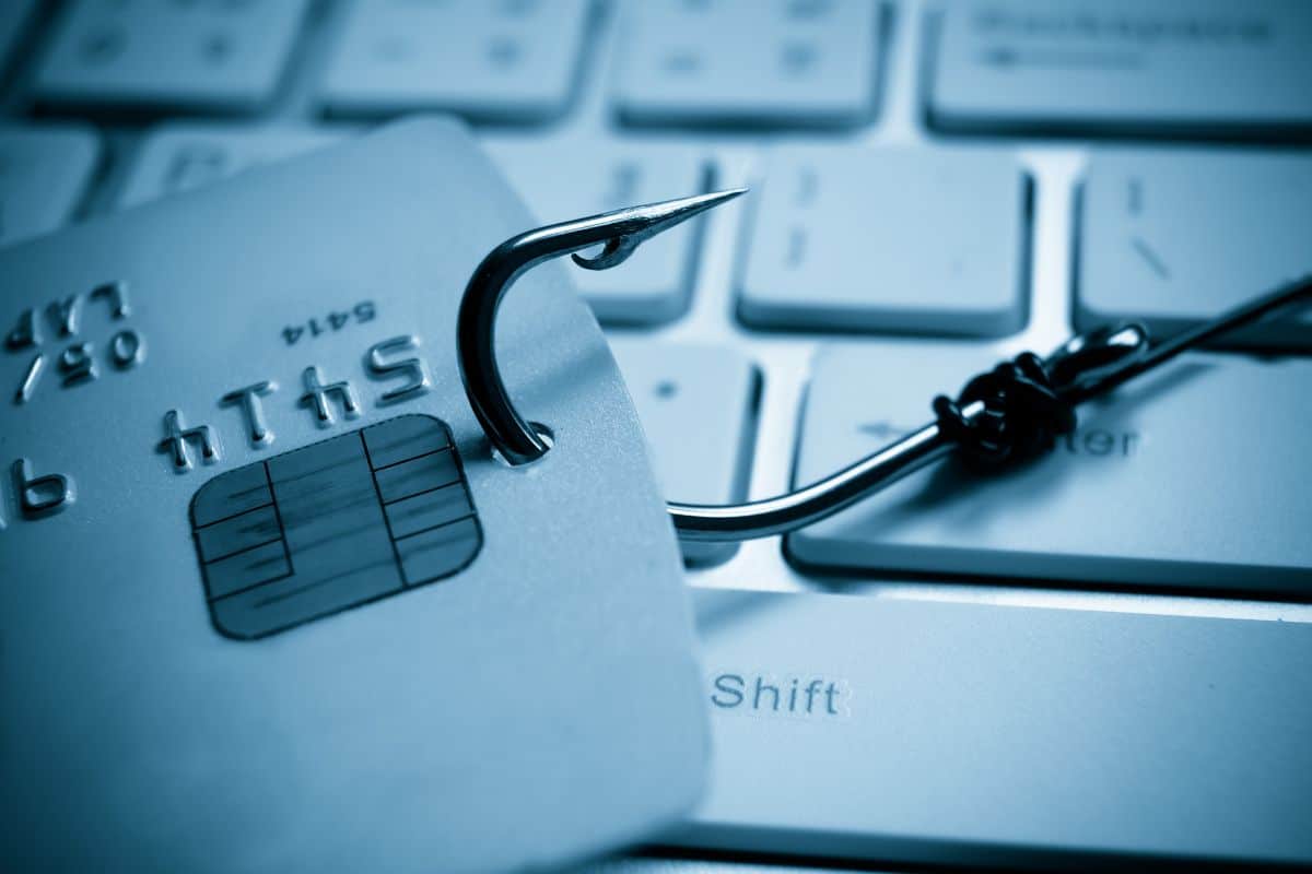 un anzuelo enganchado a una tarjeta sobre un teclado qué es el phishing